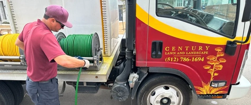 Lawn care worker standing next to a work truck in Austin, TX.